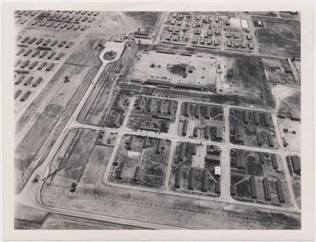 Tule Lake Center, 6 July 1945. Aerial view showing Military Police Area, left foreground, and WRA Adminstration Area in center and right background. Part of the evacuee area is shown beyond the fire break. 