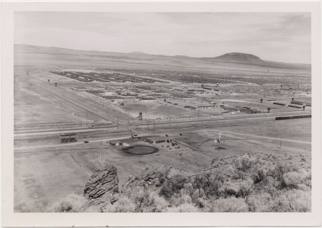 Tule Lake Center, 6 July 1945. Panoramic view from the Butte west of the Center. Military Police stable area in foreground. Military Police area (center); WRA Area (right center); evacuee area (background). Note highway and railroad. 