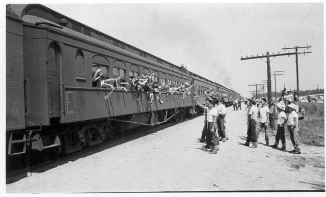 A carful of Hawaiian evacuees waving farewell as their segregation train left Jerome for the Tule Lake Center. -- Photographer: Lynn, Charles R. -- Dermott, Arkansas. 9/19/43. Source.