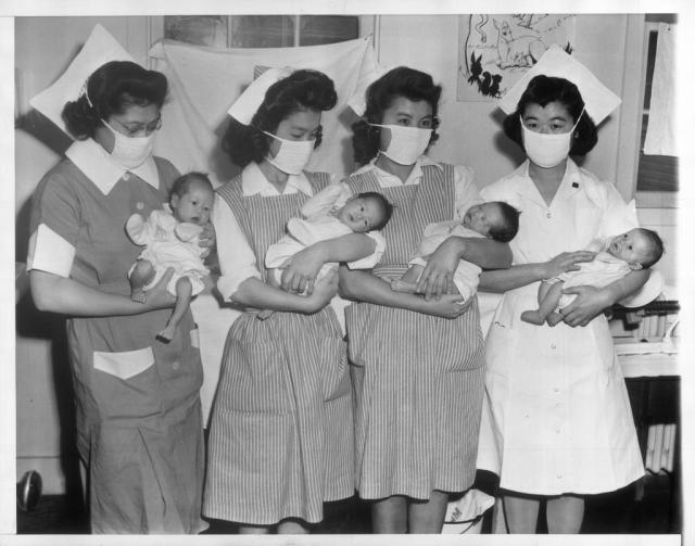 Stork Visits Relocation Center -- The stork has paid frequent visits to the Tule Lake, California, Japanese relocation center since it was opened a year ago. Here are four new arrivals held by nurses (L-R) Mary Nitta, Loomis, California; Ruby Fujioki, Seattle, Wash.; Masako Nakadoi, Loomis, California, Katsumi Ogawa, Loomis, California JARDA-6-11 1943-05-21 